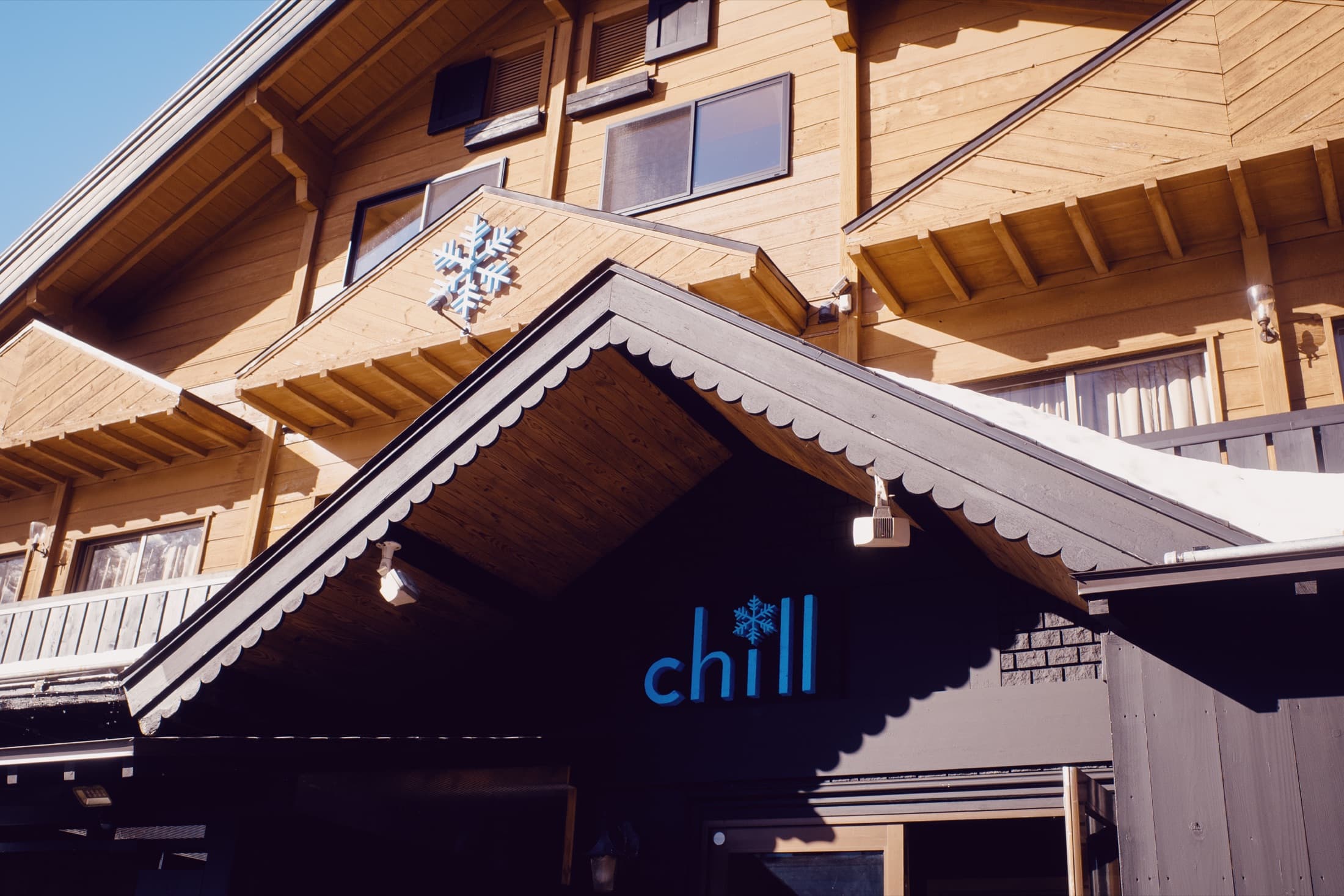 The Chill Madarao shop entrance, with the cyan chill sign and snowflake under the wooden gable of the lodge.
